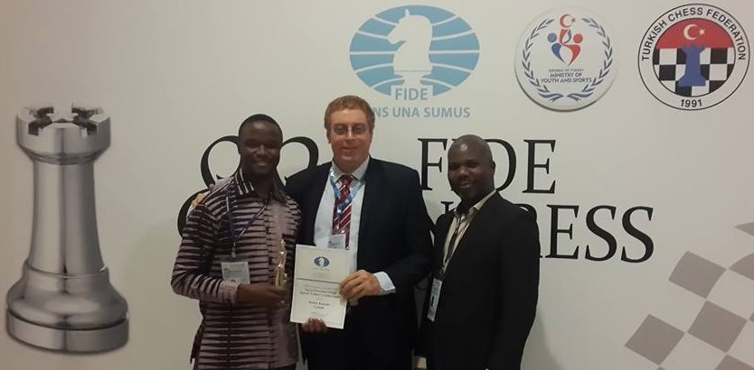 Proud recipient Robert Katende receives his prize from Dr Hesham Elgendy, FIDE Continental President and Vianney Luggya of Uganda.