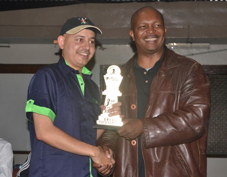A happy Mehul Gohil (left) receives his trophy from Terence Chazima. Photo credit Ann Kungu.