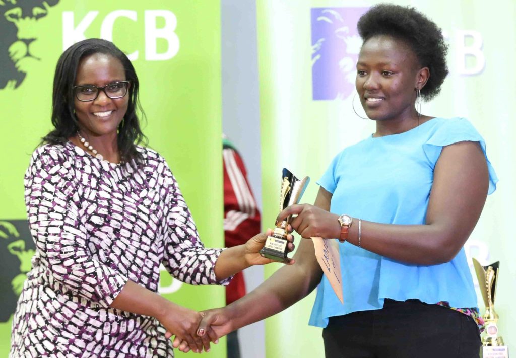 KCB Leadership Centre Manager Purity Akala (left) presents WFM Joyce Nyaruai with her prize.