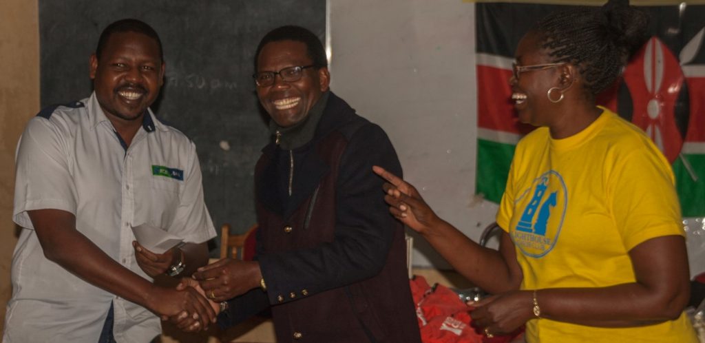 Ricky Sang (left) receives his prize from the Principal of Meru School Mr Gitari while Judith Kiragu of Lighthouse Chess Club looks on. Photo credit Eastmond Mwendia.