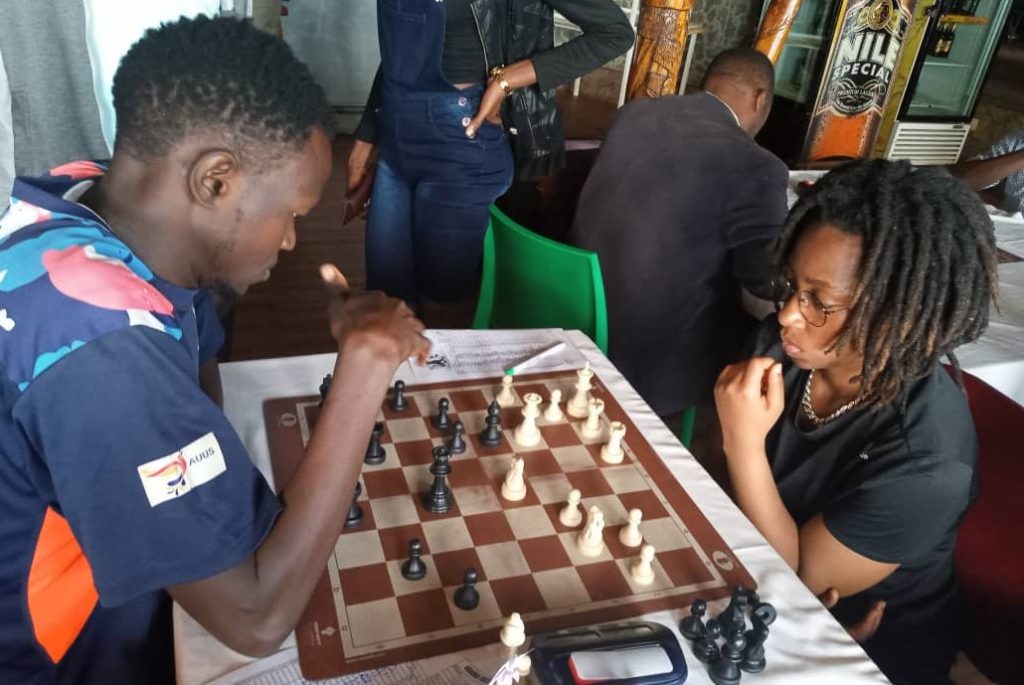 Ivan Jalagatha Mugisha of Uganda takes on one of Kenya's top lady players WCM Lucy Wanjiru.  Photo credit Pearl of Africa Chess.