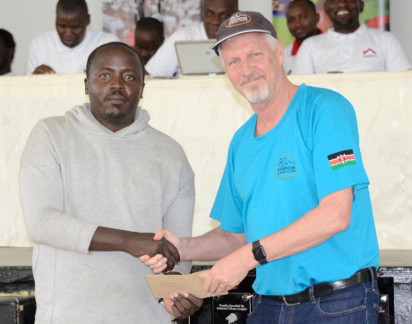 Peter Gilruth of Nairobi Chess Club receives his prize from Fred Sagwe for being the top player on board 1 with a 97.5% rate!