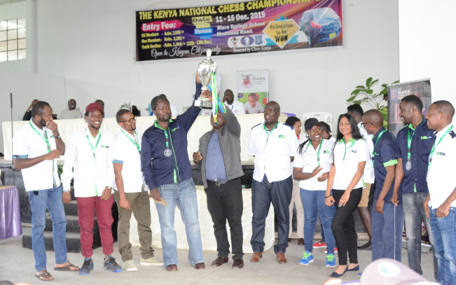 Victorious KCB Bank Chess Club receive their trophy. Captain Ben Magana (in blue shirt) holds the trophy.