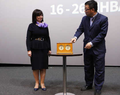 Vera Scherbina and Wang Xiaochun with the clock, that was used during the 1958 World Championship played between Mikhail Botvinnik and Vasily Smyslov in Moscow. 