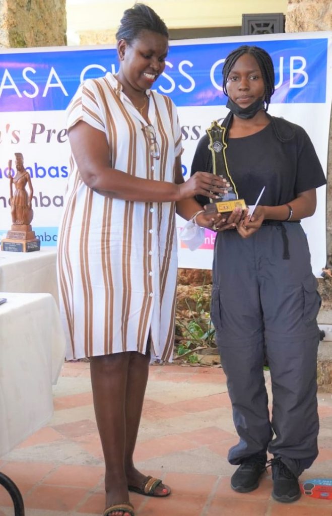 Judy Kiragu of Lighthouse Chess Club (left) presents the winner of the Ladies Section of the 2021 Mombasa Open Cynthia Abondo with her trophy.