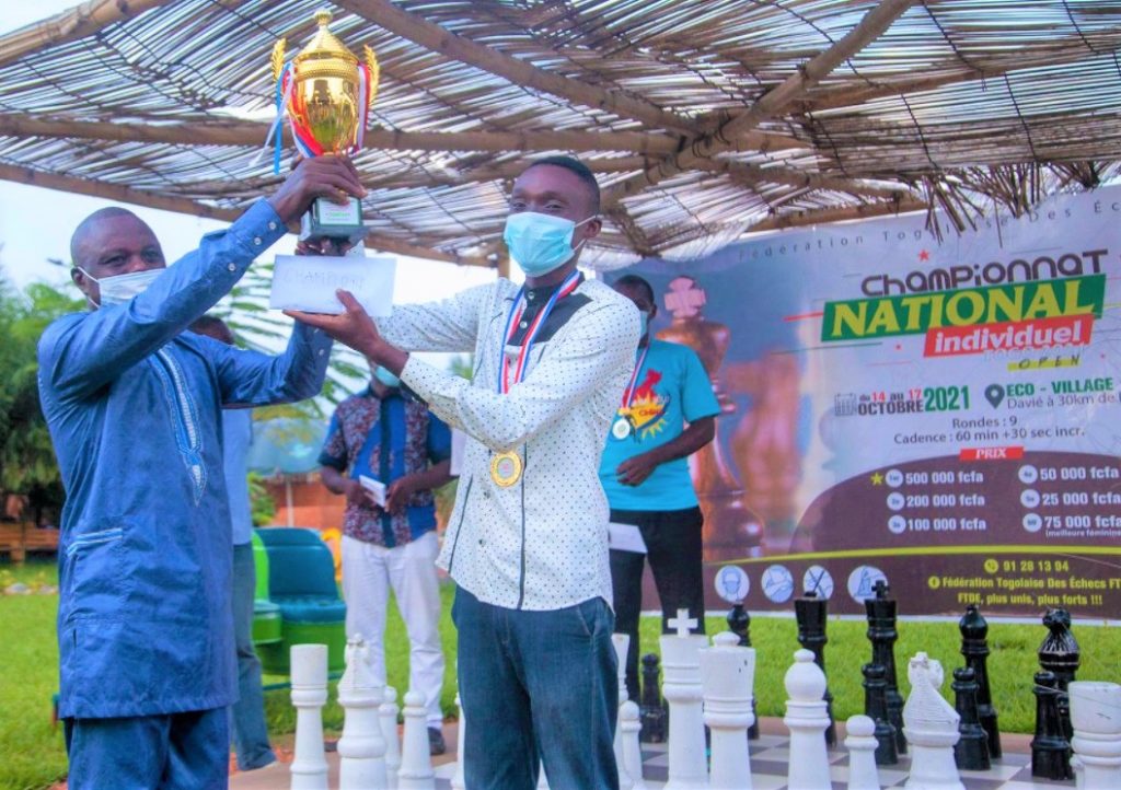 Ballebako Kokou Difendramakada Jacques receives his trophy from Mr Allengue Alak-Roufor a representative of the Ministry of Sports & Leisure for winning the 2021 Togo National Chess Championship.