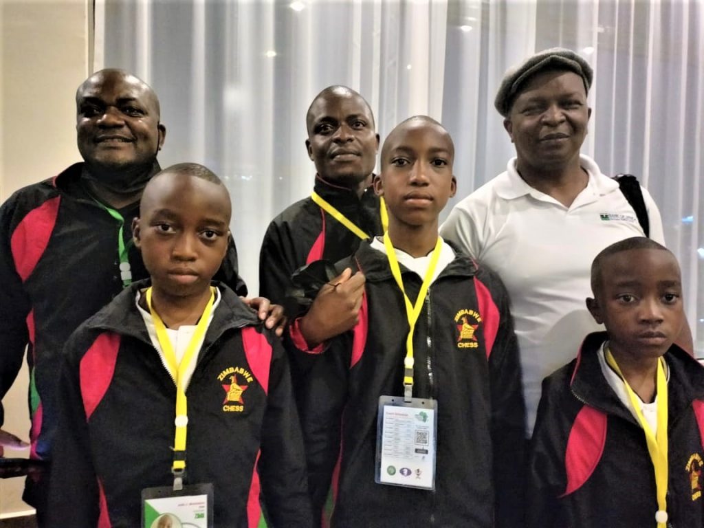 Terence Chazima the Chess Kenya Federation Assistant Treasurer (in white shirt) poses with players from Zimbabwe.
