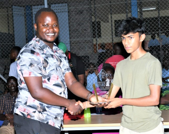 Viraj Bhaveshu Shah receives his prize for winning the Open U18 section from Andrew Owili.