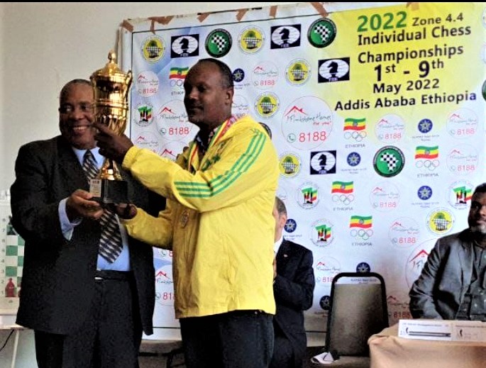CM Fekadu Jimma Desalegn of Ethiopia (right) receives his trophy from Mr Lewis Ncube the African Chess Confederation President for winning the 2022 Zone 4.4 Championship.