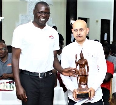 Benard Wanjala the President of the Chess Kenya Federation presents Mehul Gohil with the 'Athena' trophy.