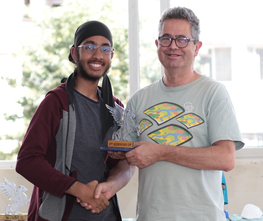 Ganeev Singh Gahir receives his trophy from Willy Simons the Chairman of Nairobi Chess Club.