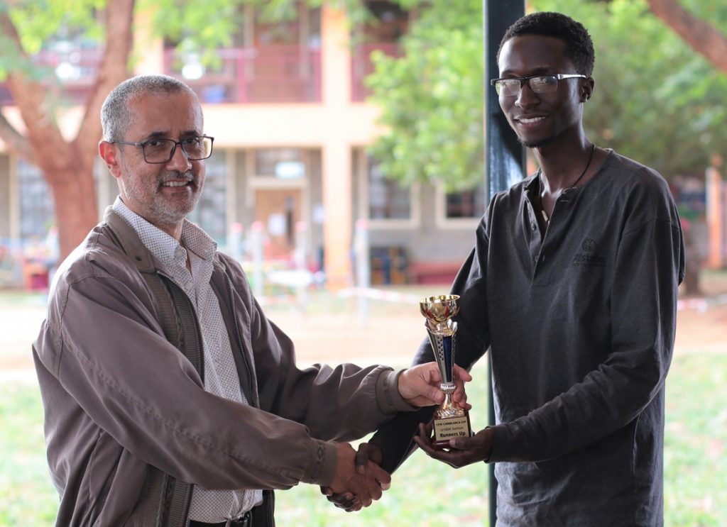 Kim Bhari (left) the organiser of the event presents the winner Stanley Omondii with his trophy.