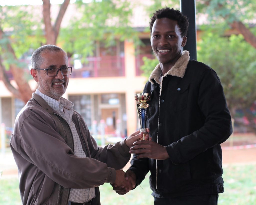 Kim Bhari (left) the organiser of the event presents the winner Zaddock Nyakundi with his trophy for winning the U1600.