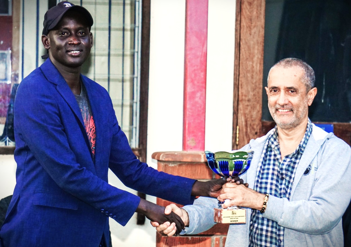 James Madol Panchol (left) receives his trophy from event organiser Kim Bhari of Nairobi Chess Club.