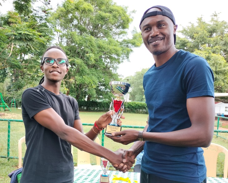 Thayu Macharia (left) presents Chris Mwanza his trophy for winning the U1600 with a perfect score of 6/6.