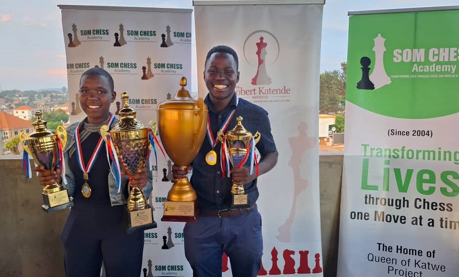 Proud winners of the 2024 SOM Open Easter Chess Championship - Patricia Kawuma and CM Emmanuel Egesa pose with their trophies.